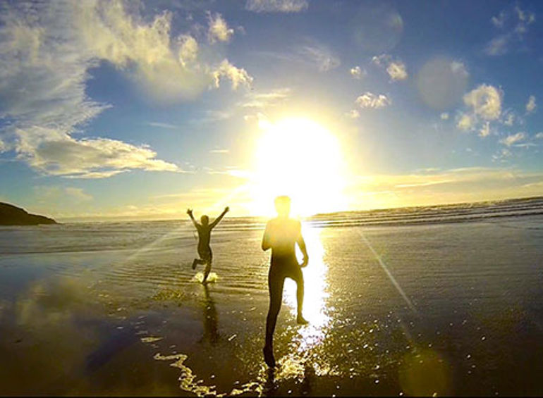 Young people running into the sea