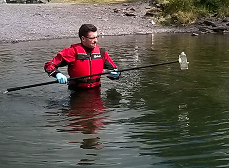 Man testing the water quality at llyn padarn