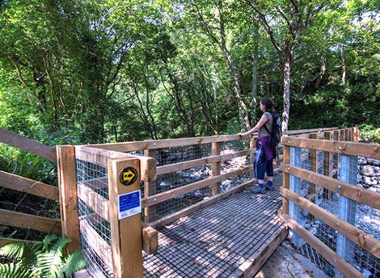 Woman using the improved path to cross a river