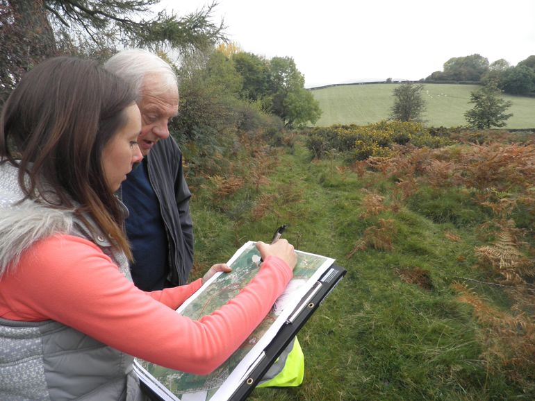 Two people marking on a map where to cut on the Halkyn Mountain