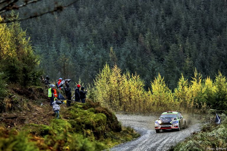Rally car on mountain road with trees in the background