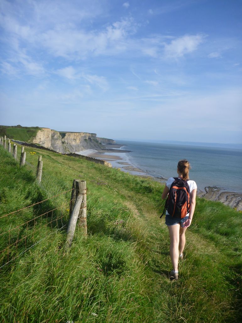 Woman walking along a coastal path