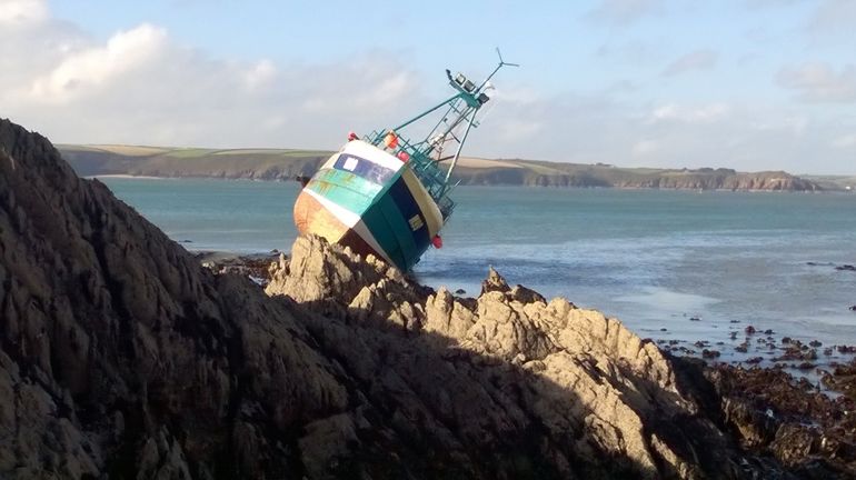 A small fishing boat stranded on some rocks