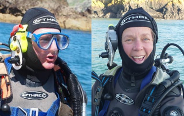 Two divers wearing full diving gear
