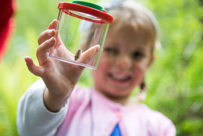 Young girl holding a bug pot