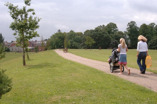 Pobol yn cerdded yn parc dinas yn Wrecsam