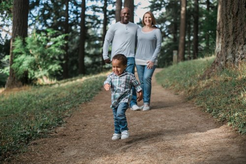 A man, woman and small boy go for a walk in a woodland