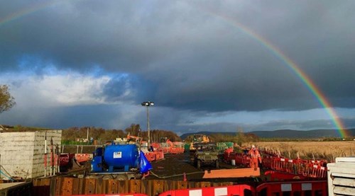 Site during rail recovery. A rainbow is in the sky.